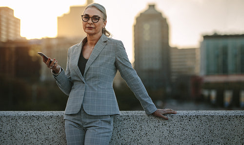 Senior businesswoman outdoors with mobile phone