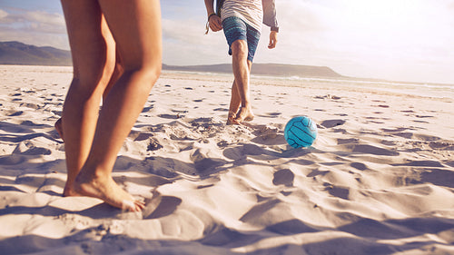 Young people playing soccer on the beach