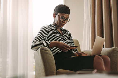 Woman on business trip doing payment using credit card and laptop