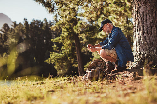 Senior hiker with compass searching for direction
