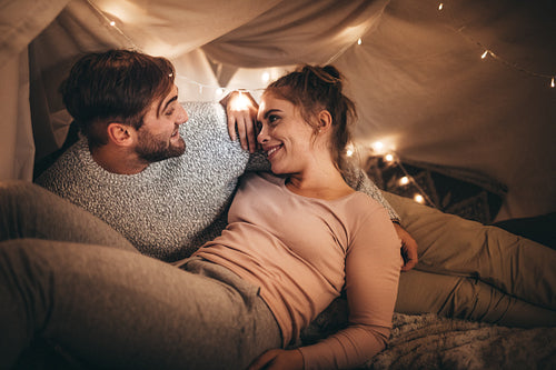 Couple talking while lying on bed