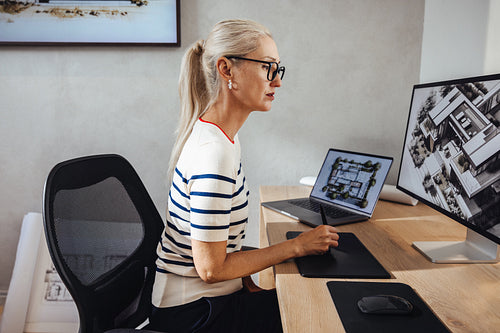 Professional female architect working on a computer with architectural designs