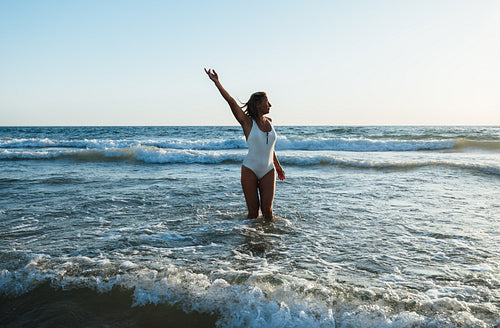 Joyful woman enjoying a sunny holiday at the beach ocean water