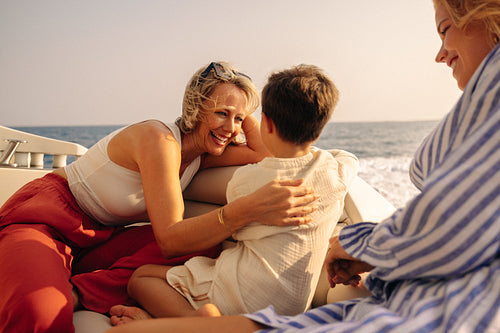 Family enjoying a holiday boat trip with grandmother, mother, and child bonding on the open sea