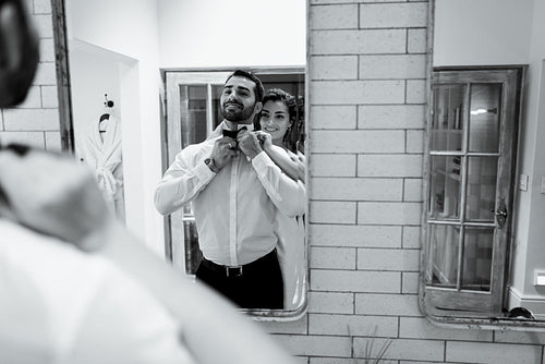 Wife helping her husband put on his tie