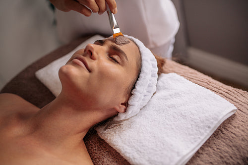 Woman getting facial nourishing mask at spa salon