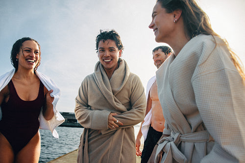 Their friendship shows as swimming friends pause together on the dock after the water.