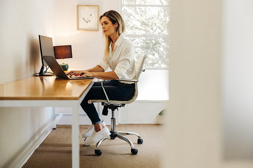 Businesswoman working on a laptop in her home office
