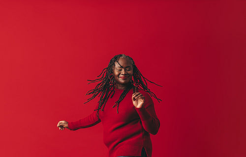 Excited black woman dancing and whipping her dreadlocks