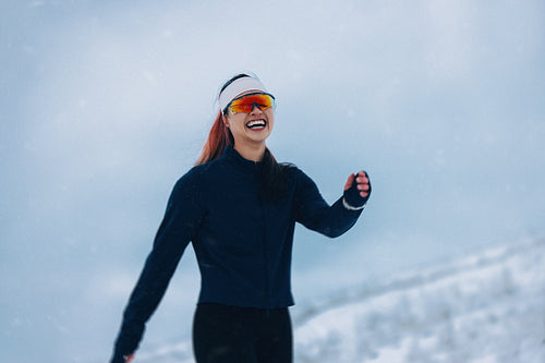 Woman in winter portrait outdoors wearing sportswear in falling snow