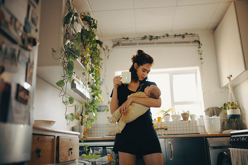 Mother holding baby in cozy kitchen