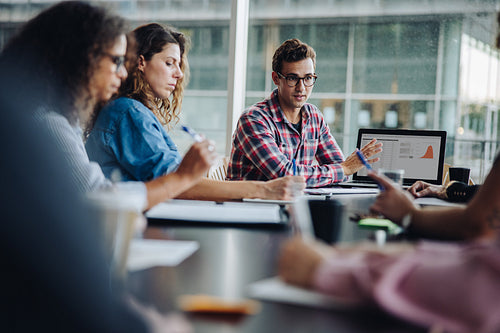 Man sharing his ideas with laptop to colleagues
