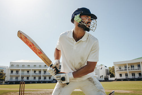 Male cricket player in action during a match on a sunny day