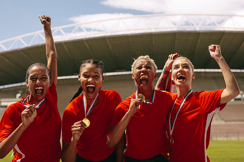 Female football team celebrating the victory at stadium