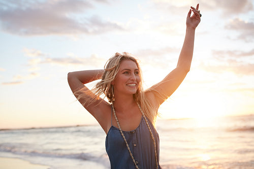 Attractive young woman enjoying on the beach at sunset