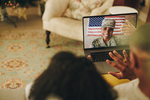 Cheerful female soldier video calling her family