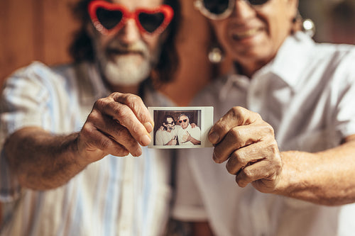Retired friends sharing their old photograph