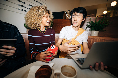 Young business friends collaborating in a cafe
