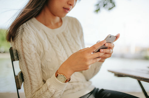 Young woman reading text message on her smartphone