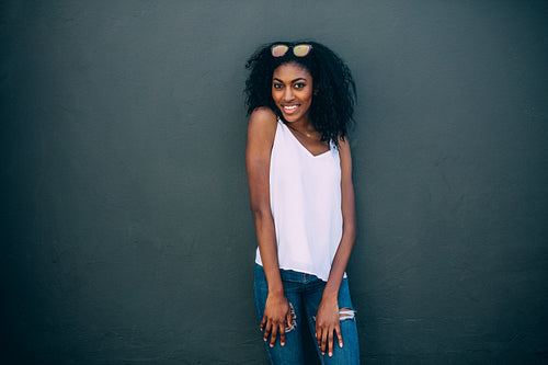 Portrait of a woman standing against a wall