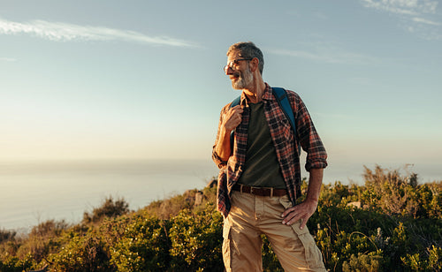 Carefree hiker looking away cheerfully on a hilltop