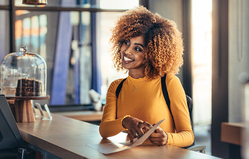 Cheerful afro american woman ordering food at a cafe