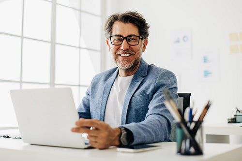 Senior software developer working on a laptop in an office