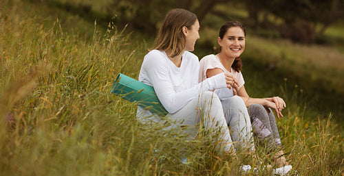 Fitness women sitting in park and talking