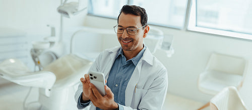 Dentist using smartphone for patient communication in clinic