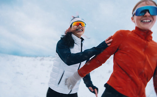 Snowfall follows women running together in winter training