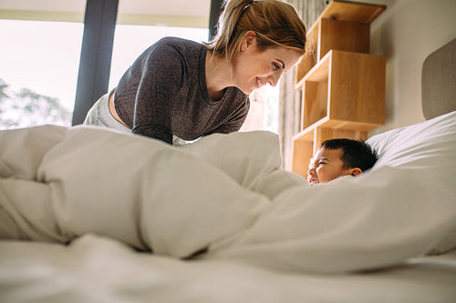Mother and son playing together on the bed