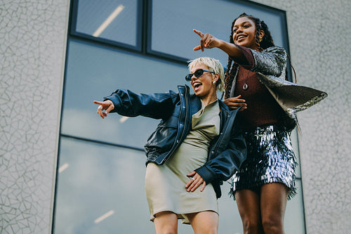 Laughing and pointing, friends having fun in the city