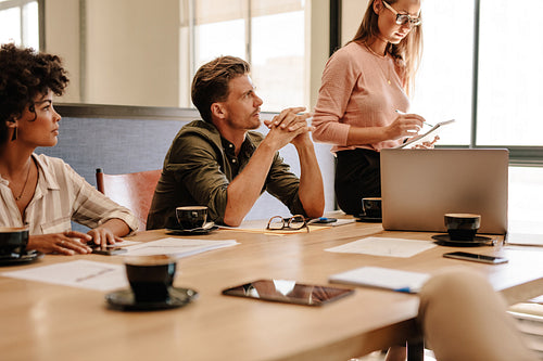 Corporate professionals sitting around table during meeting