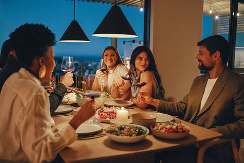 Friends enjoying a dinner with wine and food in a cozy atmosphere