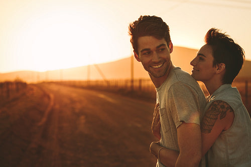 Woman embracing a man outdoors on a road trip 