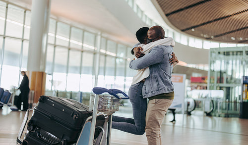 African man meeting woman arriving at airport
