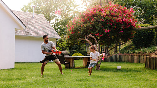 Father and son playing with water guns