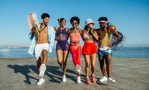 Friends group dancing on boardwalk during carnival
