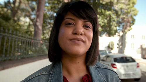 Woman standing on the sidewalk and looking at camera