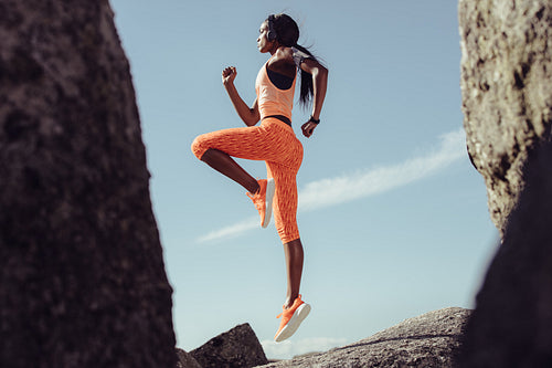 African female athlete jumping and stretching