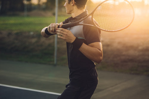 Tennis player returning the serve with a forehand