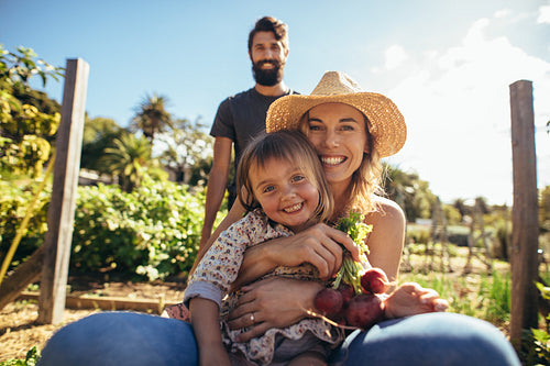 Cheerful mother and daughter enjoying in wheelbarrow