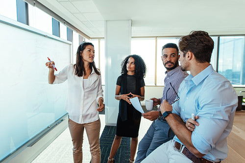 Young entrepreneurs discussing business ideas in boardroom. 