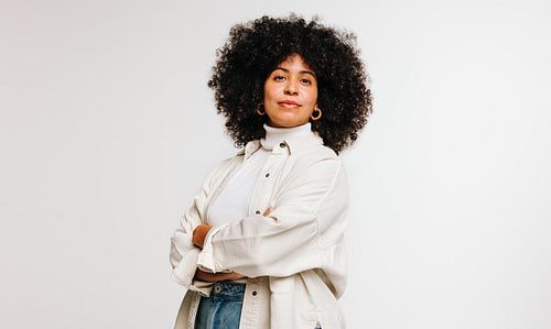 Self-confident woman with an Afro hairstyle standing in a studio