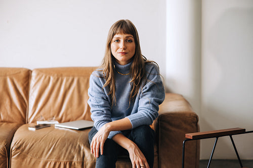 Confident young businesswoman looking at the camera in an office lobby