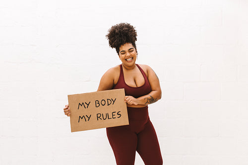 Beautiful woman holding placard of "My body my rules"