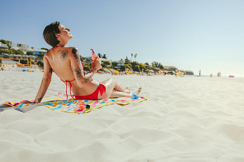 Woman in bikini sunbathing on beach
