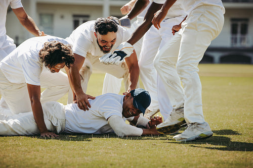 Cricket team celebrating victory with players embracing on the field