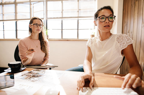 Two business women working together at office desk