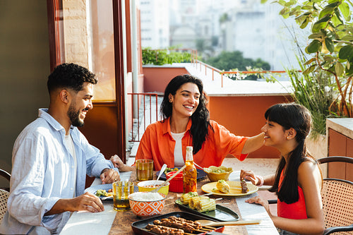 Family enjoying an outdoor meal together on a sunny patio